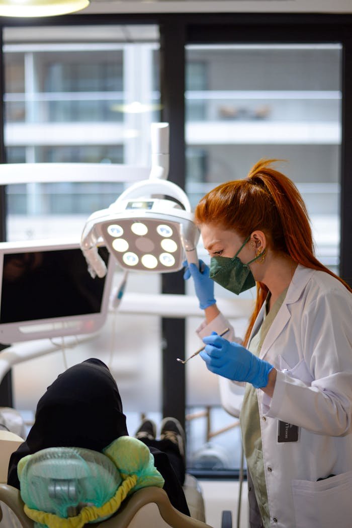 A female dentist in a modern clinic performing a dental procedure on a patient.